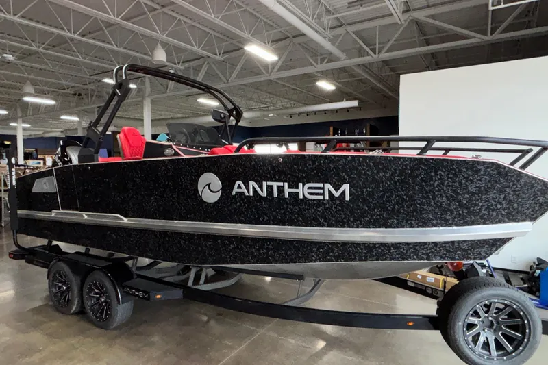 Slide: The Image of 2026 Anthem Assault VF23 boat displayed indoors on a trailer. - 8