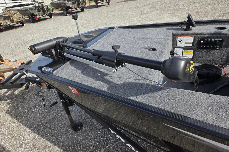 Slide: The Image of 2025 Tracker Panfish 17 boat with trolling motor on deck, parked on gravel. - 12