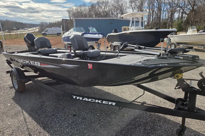 Slide: The Image of 2025 Tracker Panfish 17 boat on trailer, parked outdoors, with other boats in background. - 3