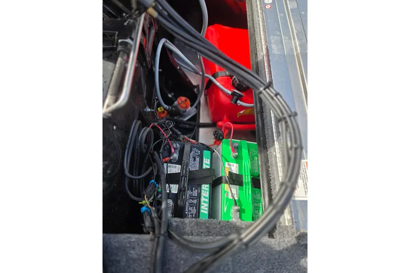 Slide: The Image of 2025 Tracker Panfish 17 boat battery compartment with wiring and red fuel tank. - 9