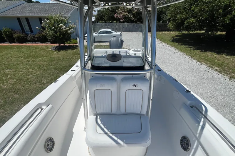 Slide: The Image of 2014 Sea Fox 226 Commander boat interior with seating and console, parked on gravel driveway. - 16