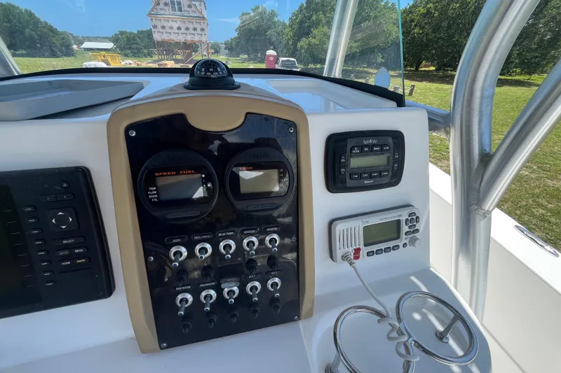 Slide: The Image of 2014 Sea Fox 226 Commander dashboard with gauges and controls, outdoor setting. - 24