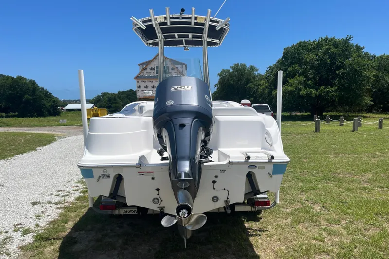 Slide: The Image of 2014 Sea Fox 226 Commander boat with powerful outboard motor, parked on grassy area. - 4