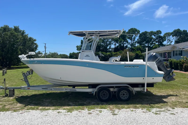 Slide: The Image of 2014 Sea Fox 226 Commander boat on trailer, parked on grass under clear blue sky. - 6