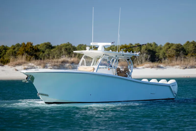 Slide: The Image of 2020 Blackwater 41 Tournament boat cruising on clear blue water near a sandy shoreline. - 3