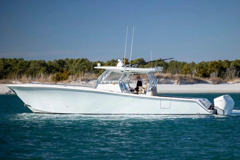 Slide: The Image of 2020 Blackwater 41 Tournament boat cruising on blue water near a sandy shoreline. - 4