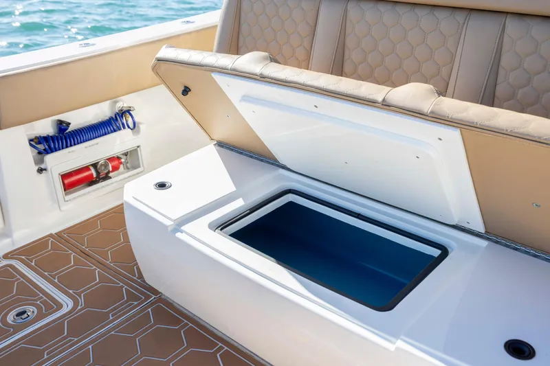 Slide: The Image of Open storage compartment on 2020 Blackwater 41 Tournament boat with tan seating and fire extinguisher. - 45
