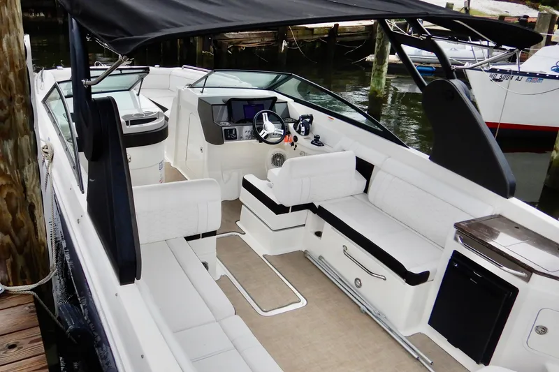 Slide: The Image of 2018 Sea Ray 290 Sundeck Outboard boat interior with seating and helm, docked at marina. - 4
