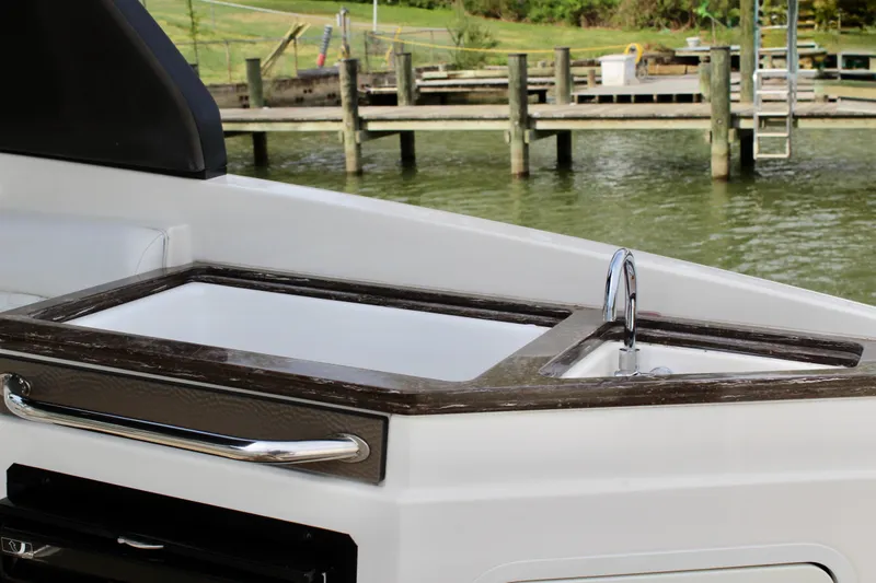 Slide: The Image of 2018 Sea Ray SDX 290 Outboard with sleek countertop by the water. - 24