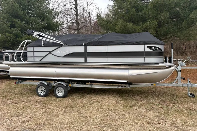 The Image of 2026 Bentley Pontoons Legacy 223 Navigator on trailer, covered, parked on grass. - 0