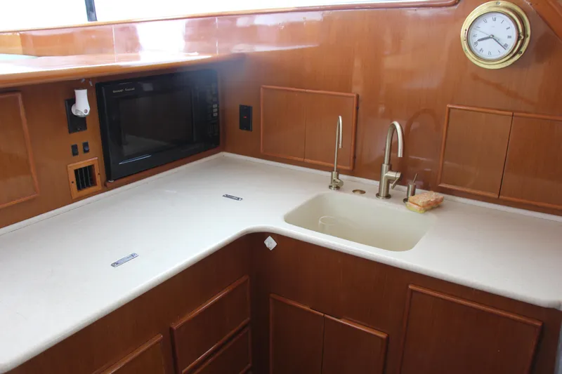 Slide: The Image of Wooden boat kitchen with sink, microwave, and clock; Post 50 model, year 2000. - 10