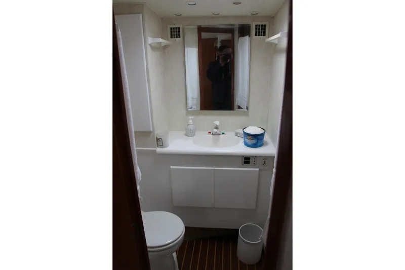 Slide: The Image of Small bathroom with mirror, sink, and toilet in a 2000 Post 50 model. - 14