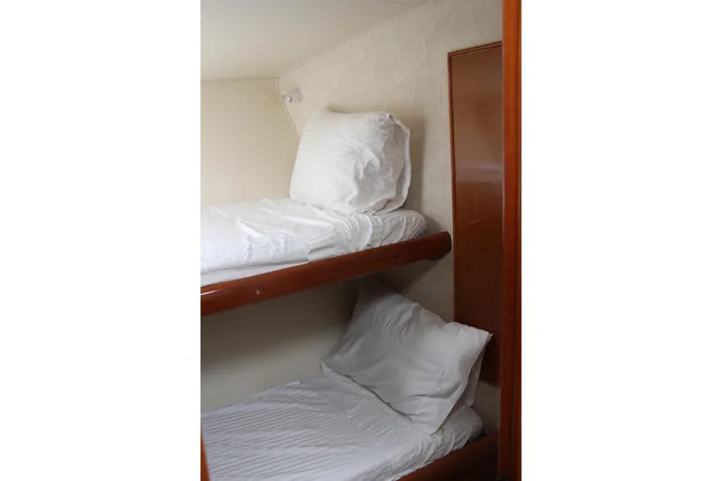 Slide: The Image of Bunk beds with white bedding in a compact room, Post 50 model, year 2000. - 17