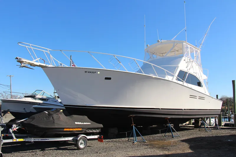 Slide: The Image of White 2000 Post 50 yacht on dry dock with a covered jet ski nearby. - 3
