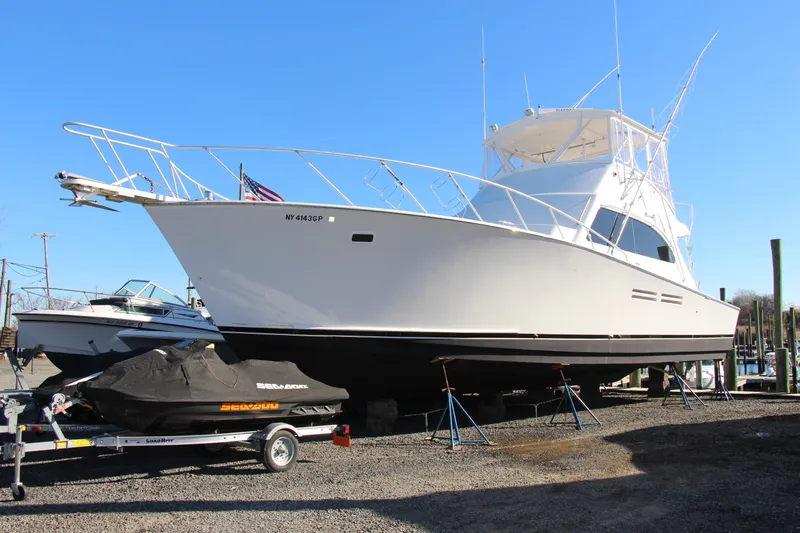 Slide: The Image of White Post 50 yacht from 2000 on dry dock, with jet ski nearby. - 4