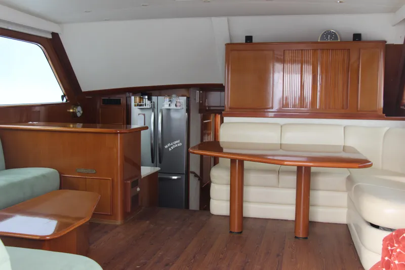 Slide: The Image of Luxurious yacht interior with wooden furnishings, cream seating, and modern kitchen area. Post 50, 2000 model. - 5