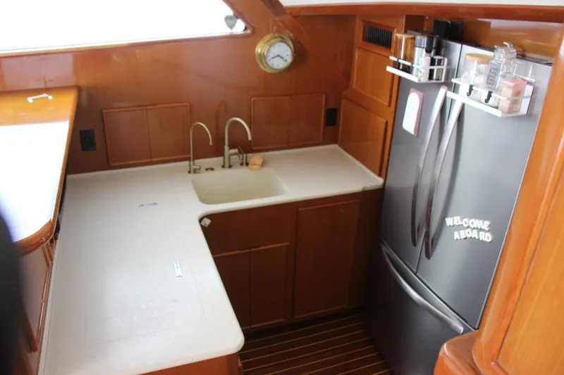 Slide: The Image of Small yacht kitchen with wooden cabinets, stainless steel fridge, and sink. Post 50, year 2000. - 9