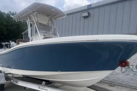 The Image of 2026 Pioneer 202 Islander boat with blue hull on trailer, parked near a building. - 0