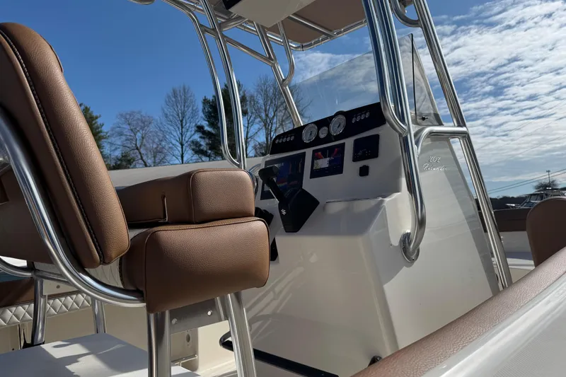 Slide: The Image of 2026 Pioneer 202 Islander boat interior with brown seating and modern dashboard under blue sky. - 7