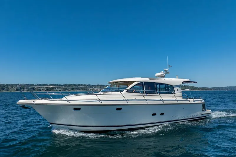 The Image of 2022 Nimbus 405 Coupé yacht cruising on open water under clear blue sky. - 0