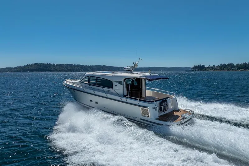Slide: The Image of 2022 Nimbus 405 Coupé cruising on open water under clear blue skies. - 55