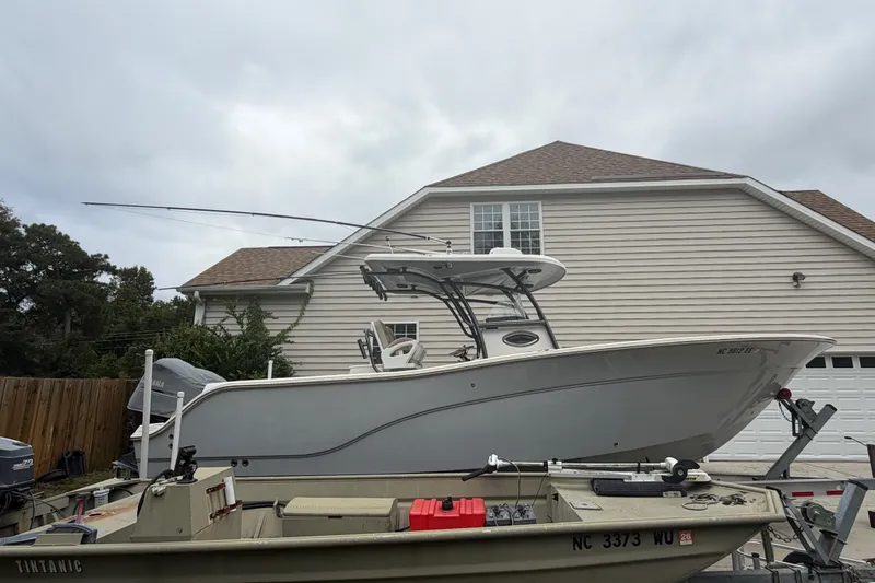 Slide: The Image of 2015 Sea Fox 286 Commander boat parked in front of a house, overcast sky. - 4