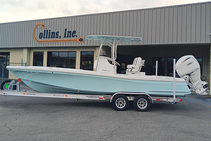 The Image of 2026 BlackJack 256 Coastal boat on trailer outside Collins, Inc. dealership. - 1