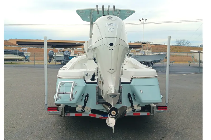 Slide: The Image of 2026 BlackJack 256 Coastal boat with powerful outboard motor, displayed in a marina setting. - 6