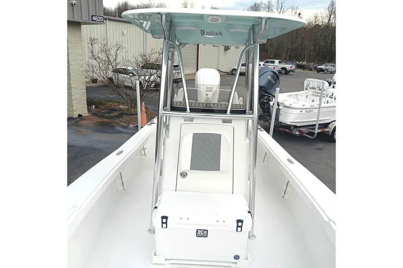 Slide: The Image of 2026 BlackJack 256 Coastal boat with T-top and console, parked outdoors. - 9