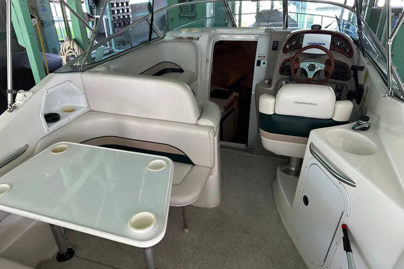Slide: The Image of 1998 Chaparral Signature 2600 boat interior with seating, table, and steering console. - 11