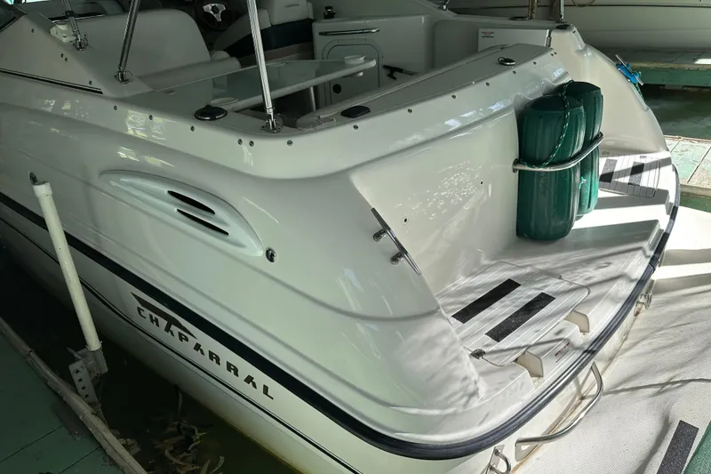 Slide: The Image of 1998 Chaparral Signature 2600 boat, rear view, docked with green fenders. - 12