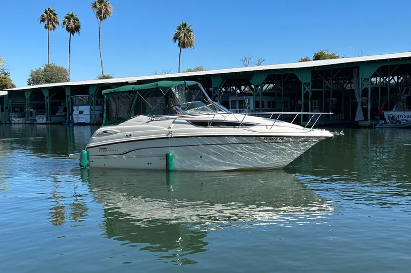 Slide: The Image of 1998 Chaparral Signature 2600 boat docked on calm water with palm trees. - 15