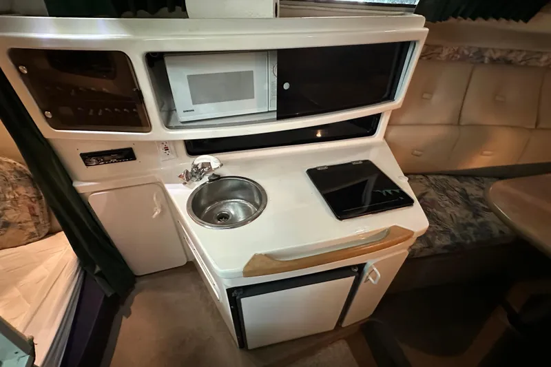 Slide: The Image of 1998 Chaparral Signature 2600 boat interior with kitchenette, sink, and microwave. - 3