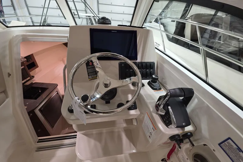 Slide: The Image of 2026 Boston Whaler 285 Conquest helm with steering wheel and control panel. - 14