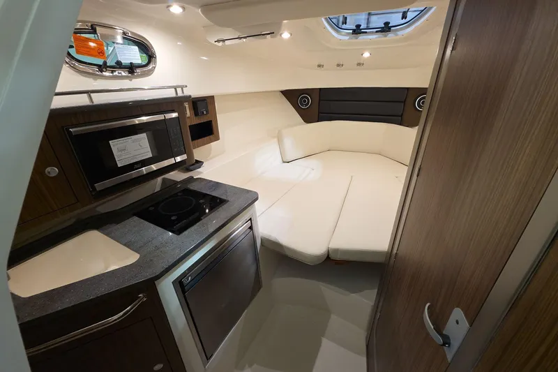 Slide: The Image of 2026 Boston Whaler 285 Conquest cabin interior with kitchenette and seating area. - 15