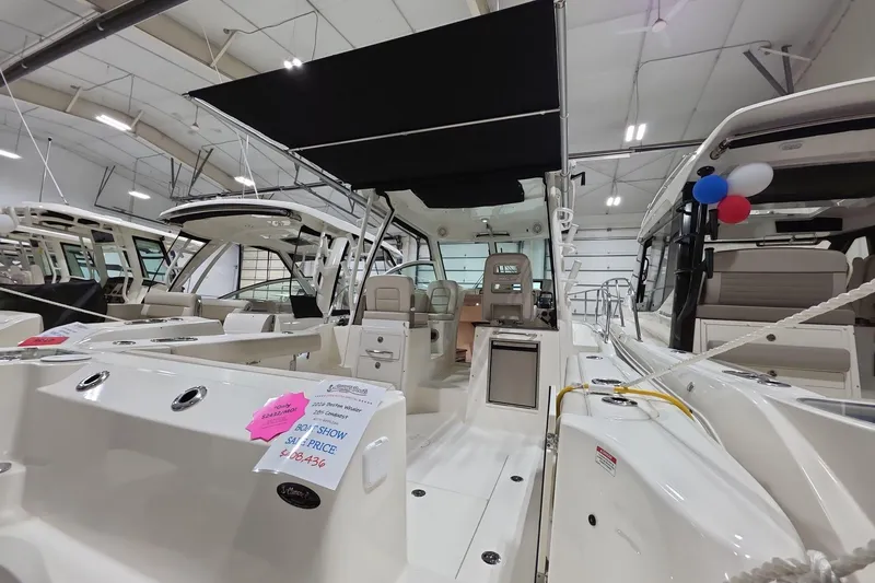 Slide: The Image of 2026 Boston Whaler 285 Conquest boat displayed indoors with promotional signage. - 17