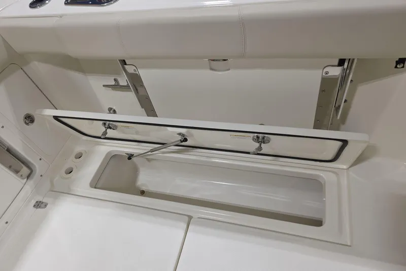 Slide: The Image of 2026 Boston Whaler 285 Conquest storage compartment with open hatch, showcasing interior design. - 19