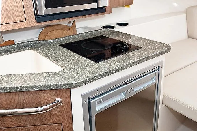 Slide: The Image of Manufacturer Provided Image: 2026 Boston Whaler 285 Conquest interior kitchen with modern appliances and sleek countertop design. - 22