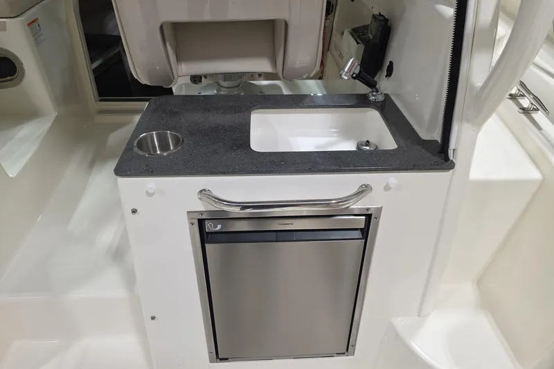 Slide: The Image of 2026 Boston Whaler 285 Conquest interior with sink and mini fridge. - 9