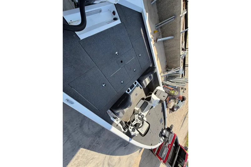 Slide: The Image of 2020 Vexus AVX 2080 boat interior with steering wheel and seating, parked near a red vehicle. - 16