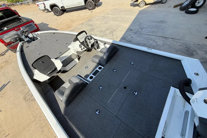 Slide: The Image of 2020 Vexus AVX 2080 boat interior with seating and control panel, parked near trucks. - 18