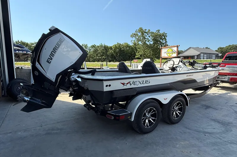 Slide: The Image of 2020 Vexus AVX 2080 boat with Evinrude engine on a trailer, parked outdoors. - 2