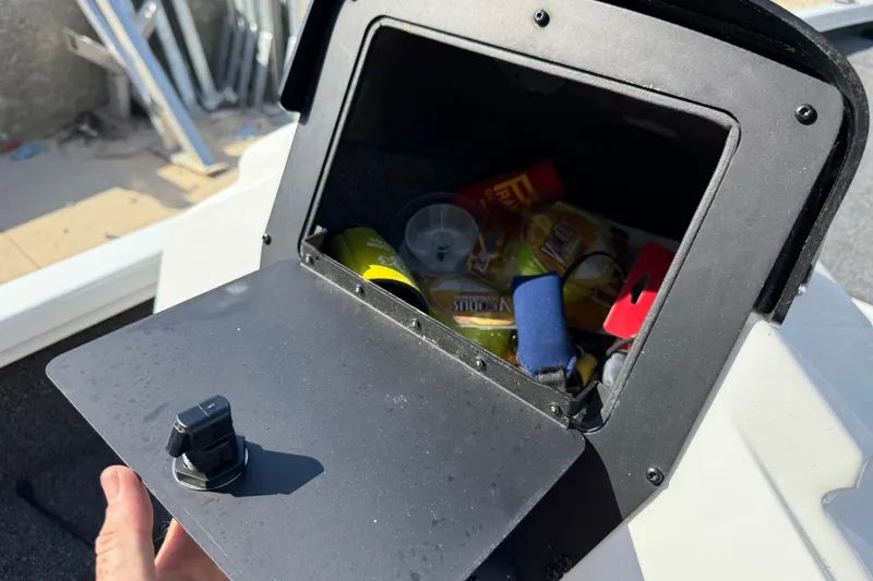Slide: The Image of Open storage compartment on 2020 Vexus AVX 2080 boat, containing various items. - 32