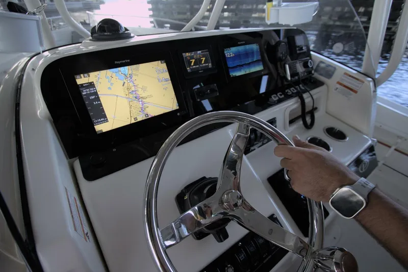 Slide: The Image of Helm of 2001 Pursuit 3070 Center Console with navigation screens and steering wheel. - 11