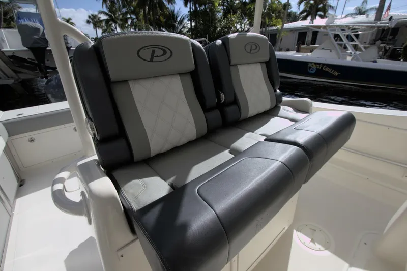 Slide: The Image of 2001 Pursuit 3070 Center Console boat seats with logo, docked near water. - 13