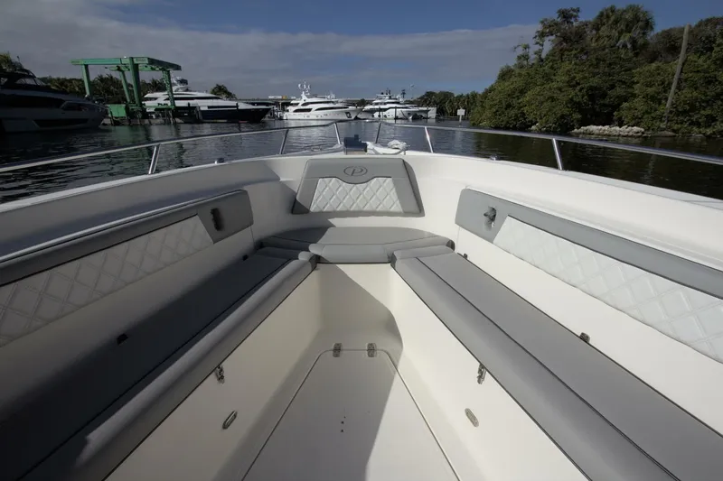 Slide: The Image of 2001 Pursuit 3070 Center Console boat interior with cushioned seating, docked near yachts. - 5