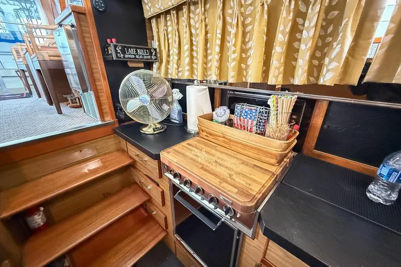 Slide: The Image of 1969 Chris-Craft 338 Commander kitchen with stove, fan, and wooden cabinetry. - 17