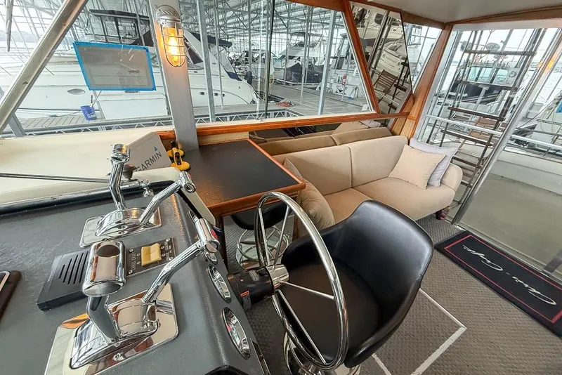 Slide: The Image of 1969 Chris-Craft 338 Commander helm with steering wheel, controls, and beige sofa in cabin. - 7