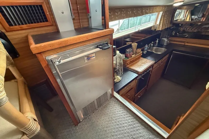 Slide: The Image of Interior of 1969 Chris-Craft 338 Commander boat, featuring a compact kitchen area. - 10