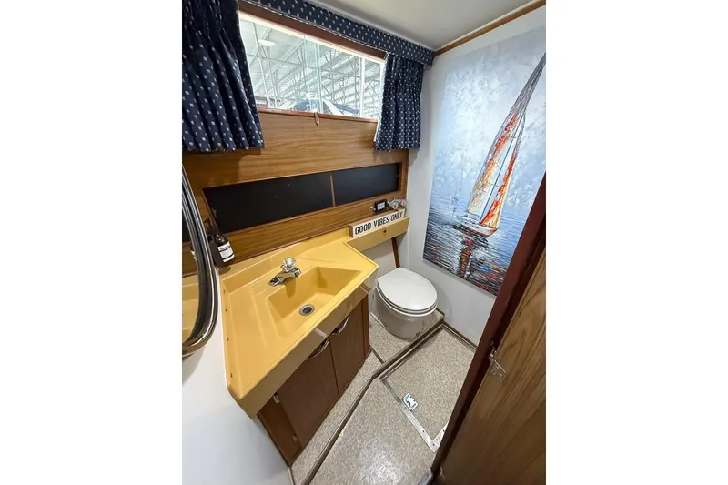 Slide: The Image of Bathroom interior of 1969 Chris-Craft 338 Commander with yellow sink and sailboat artwork. - 15